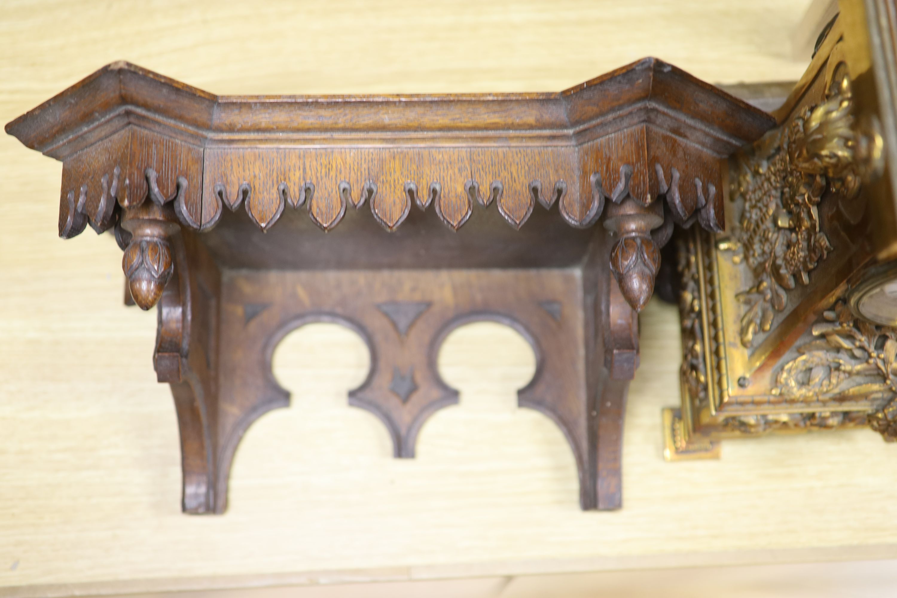 A late 19th century French cast brass cased eight day mantel clock and a carved oak clock bracket, height 50cm